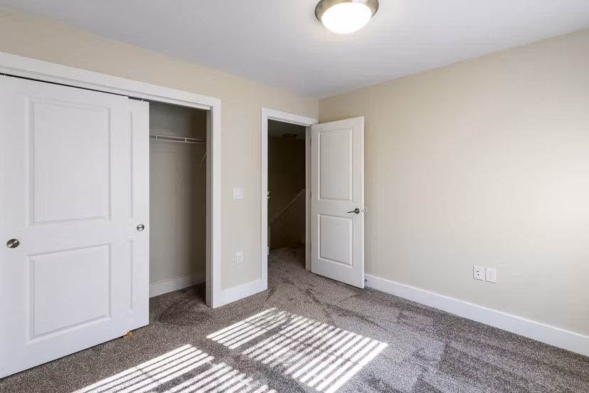 Elegant bedroom with contemporary decor and large windows in Creekstone Twin Homes, Greystar luxury apartments