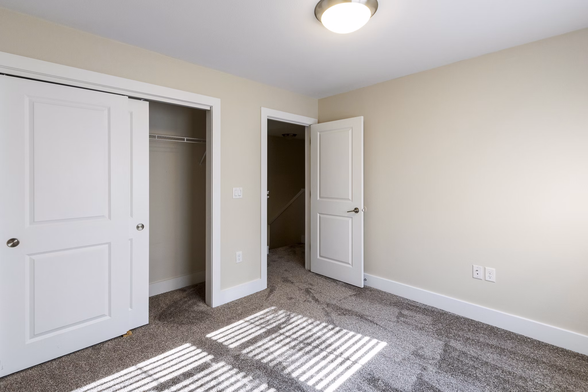 Elegant bedroom with contemporary decor and large windows in Creekstone Twin Homes, Greystar luxury apartments
