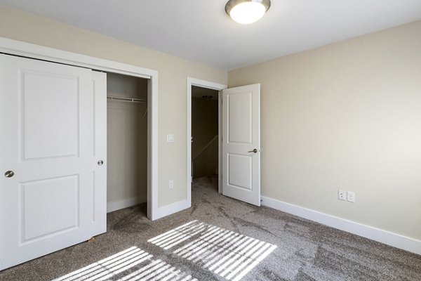 Elegant bedroom with contemporary decor and large windows in Creekstone Twin Homes, Greystar luxury apartments