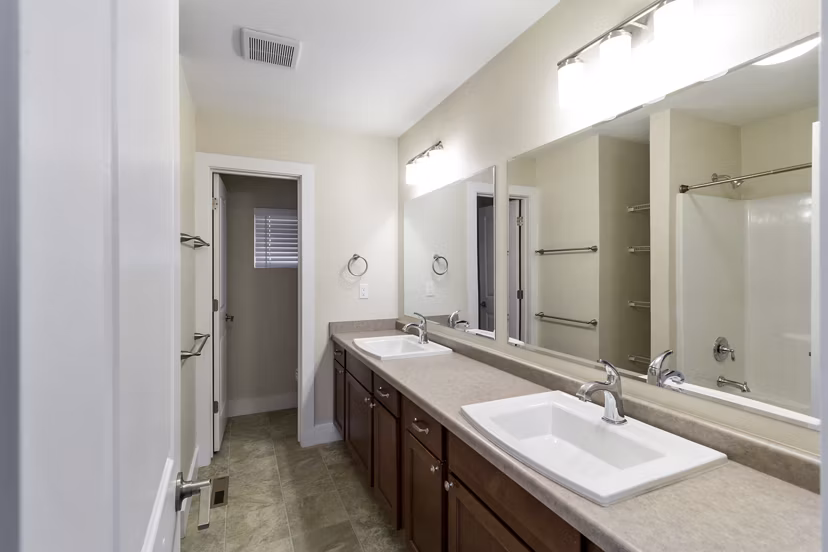 Modern bathroom featuring sleek fixtures and double vanity in Creekstone Twin Homes