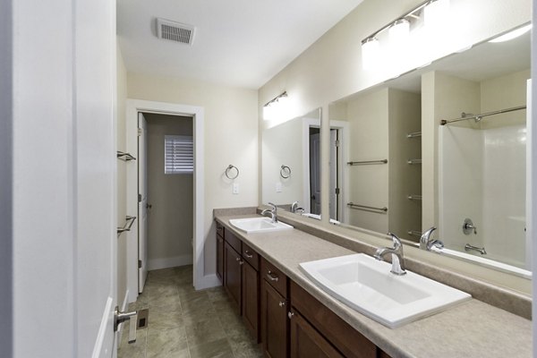 Modern bathroom featuring sleek fixtures and double vanity in Creekstone Twin Homes
