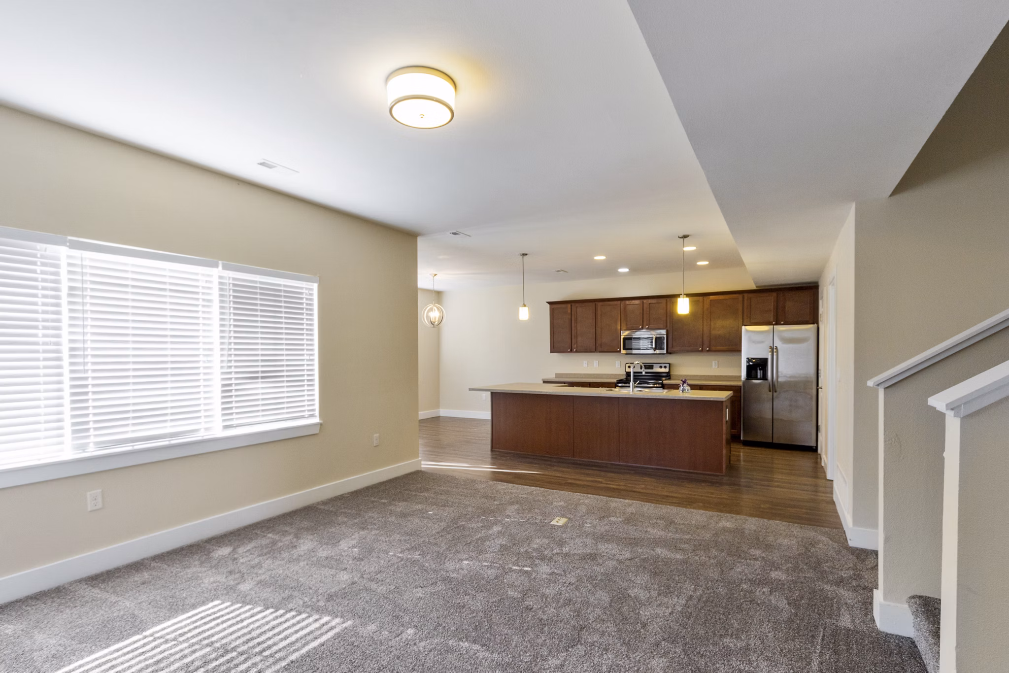 Open-concept kitchen with granite countertops and modern appliances in Creekstone Twin Homes