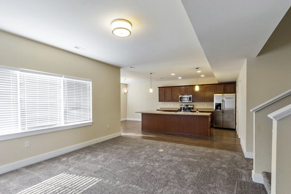 Open-concept kitchen with granite countertops and modern appliances in Creekstone Twin Homes