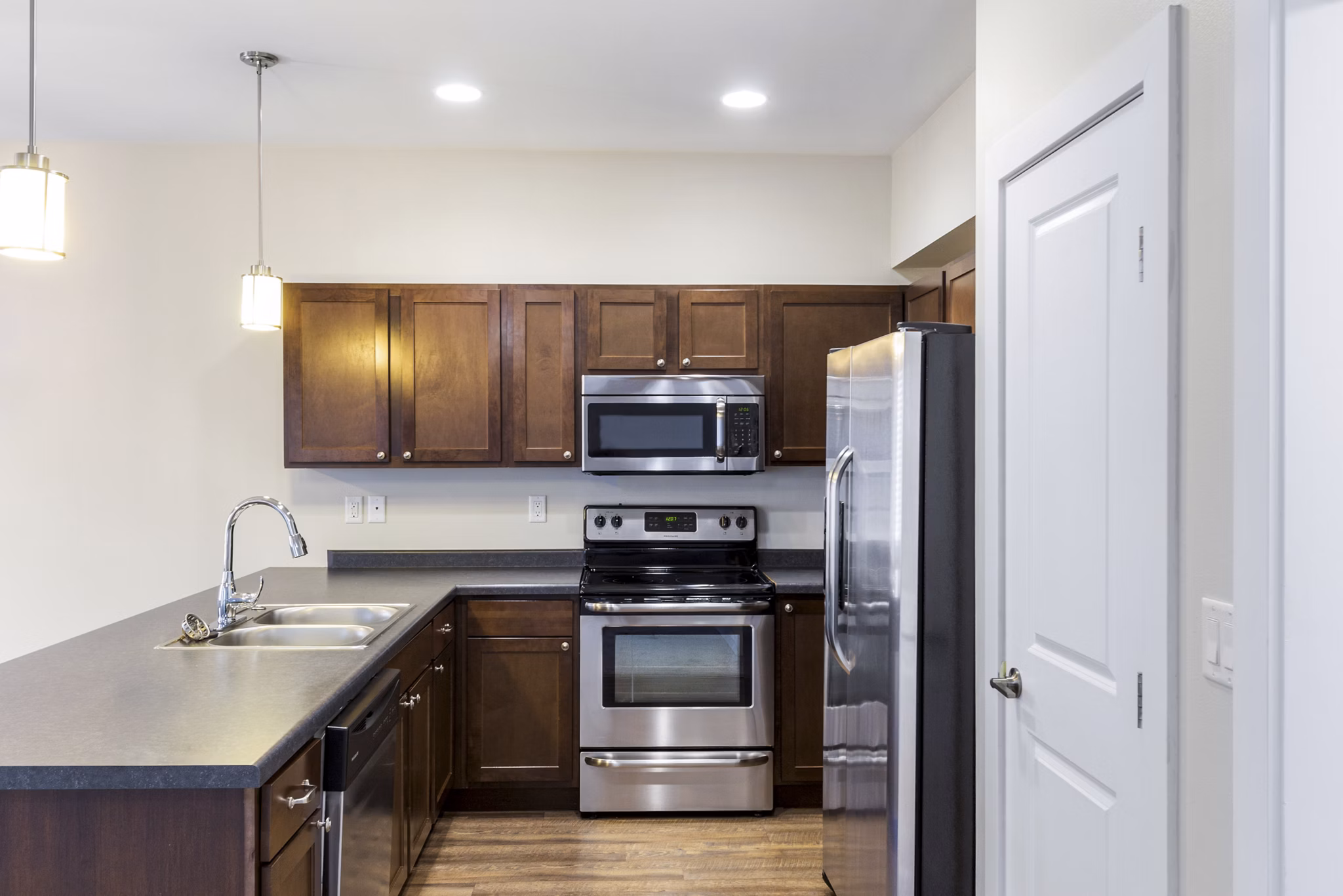 Spacious kitchen with modern appliances and island in Creekstone Twin Homes luxury apartments