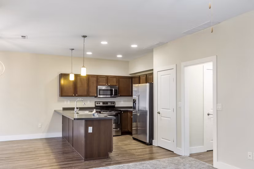 Modern kitchen with stainless steel appliances at Creekstone Twin Homes: luxury apartments by Greystar