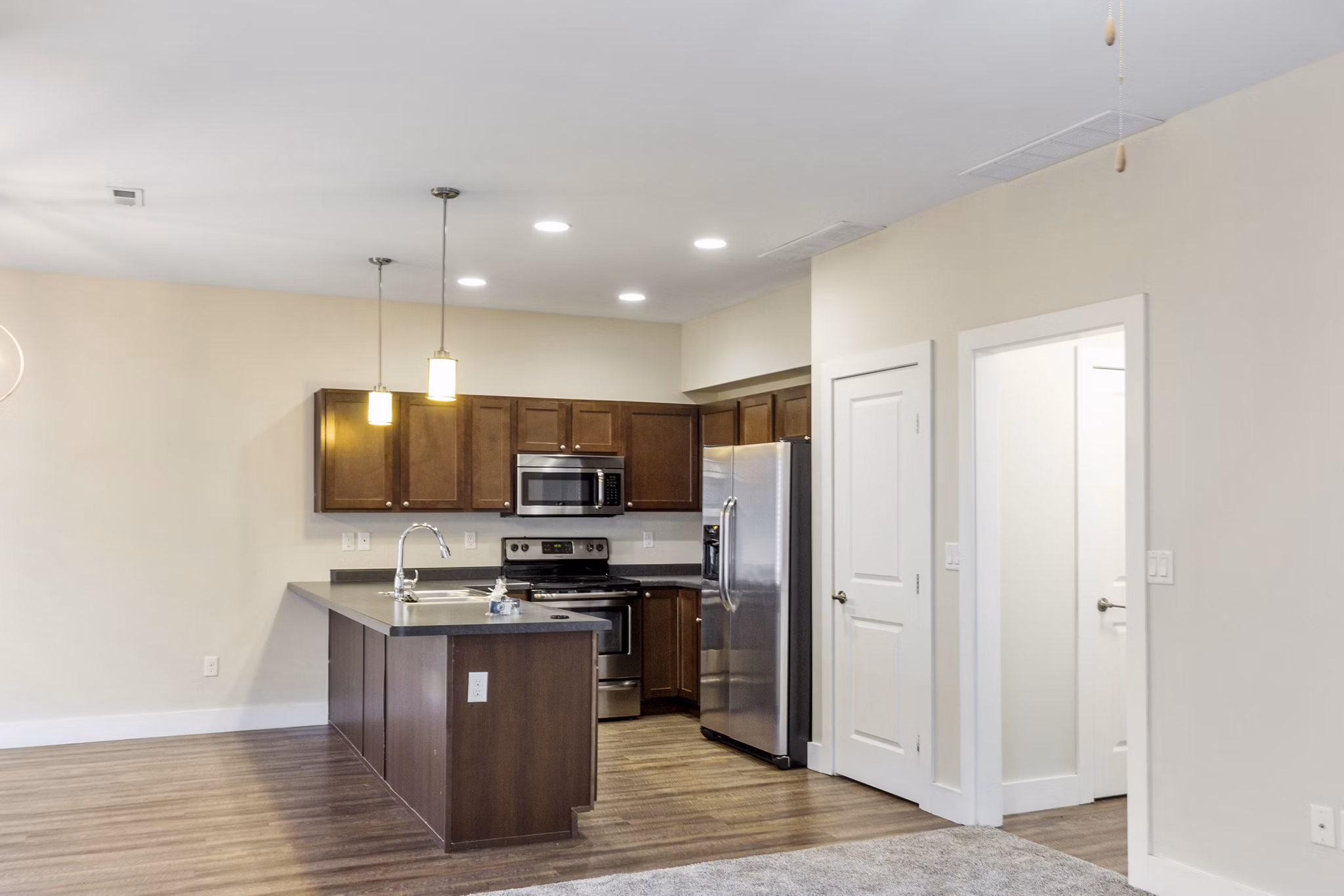 Modern kitchen with stainless steel appliances at Creekstone Twin Homes: luxury apartments by Greystar
