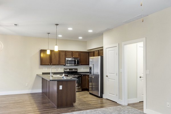 Modern kitchen with stainless steel appliances at Creekstone Twin Homes: luxury apartments by Greystar