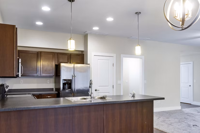 Modern kitchen with stainless steel appliances in Creekstone Twin Homes luxury apartments