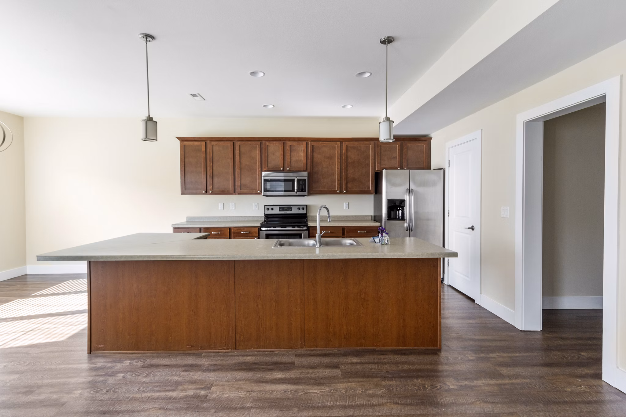 Modern kitchen with granite countertops and stainless steel appliances at Creekstone Twin Homes luxury apartments