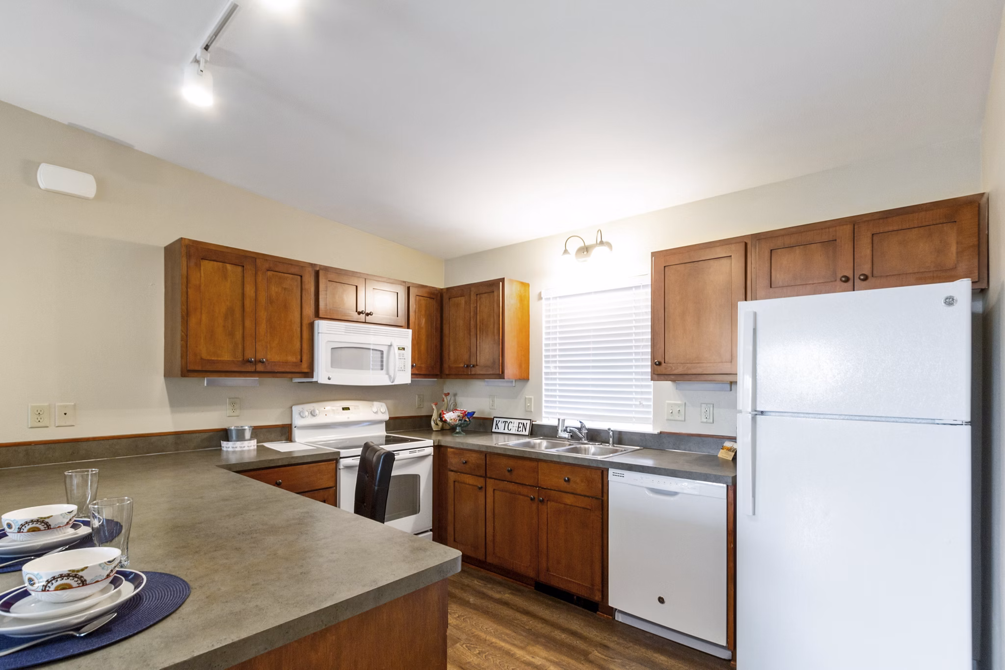 Modern kitchen featuring stainless steel appliances and granite countertops at Creekstone Twin Homes, a luxury apartment by Greystar