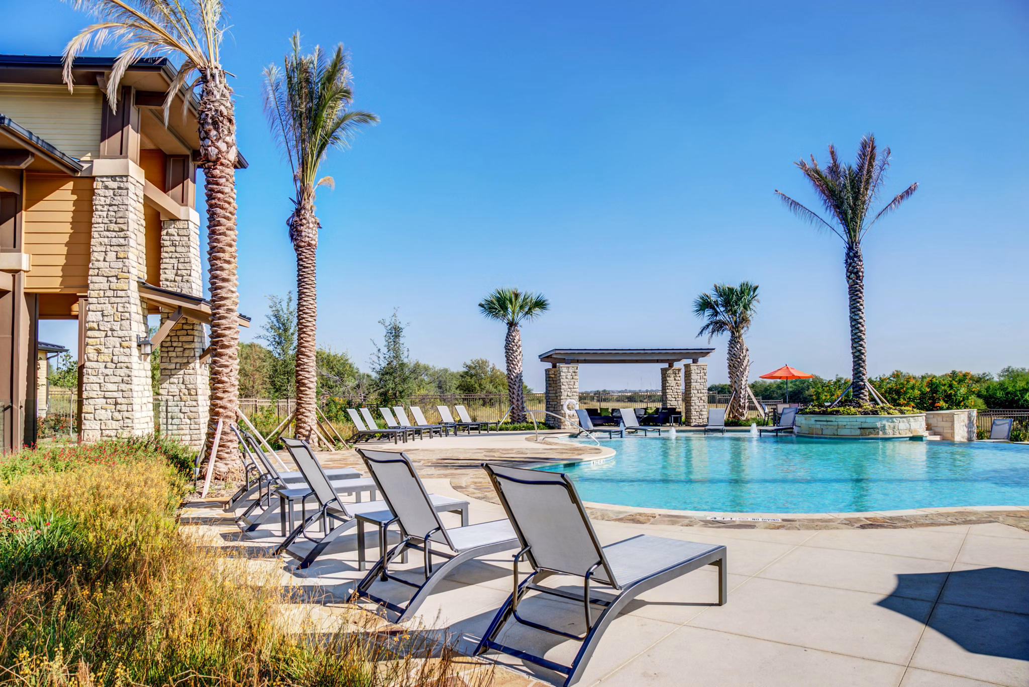 Resort-style pool with lounging area at Dalian Monterrey Village Apartments, providing a luxury experience for residents
