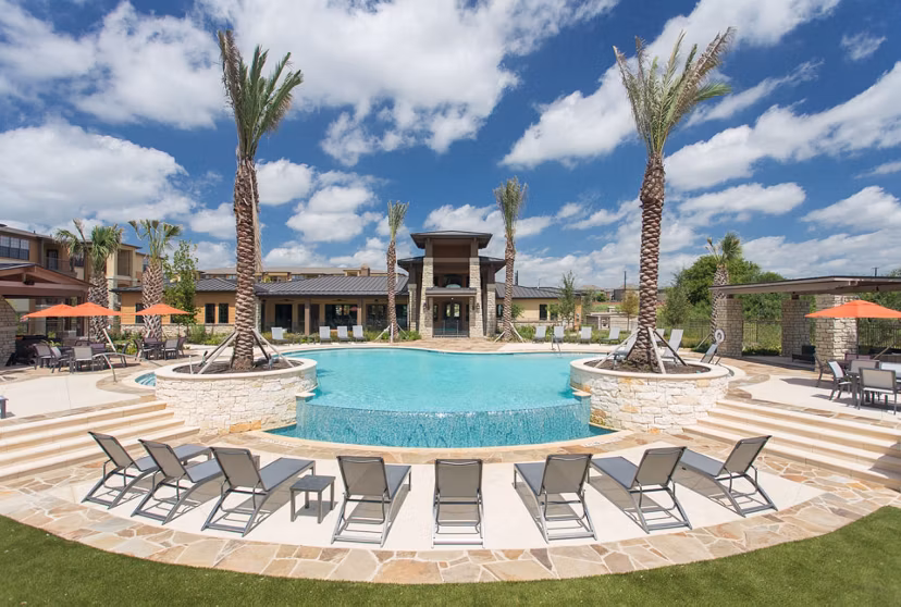 Large outdoor pool at Dalian Monterrey Village Apartments with lounge chairs and landscaping