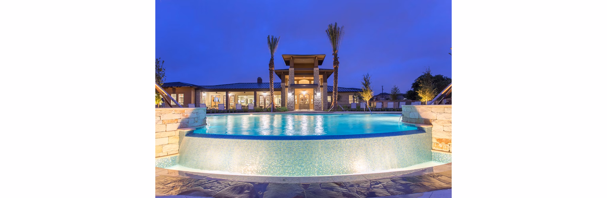 Dalian Monterrey Village: Relaxing pool area with lounge chairs and palm trees in a luxury apartment community in San Antonio