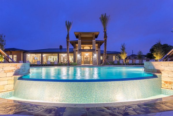 Dalian Monterrey Village: Relaxing pool area with lounge chairs and palm trees in a luxury apartment community in San Antonio