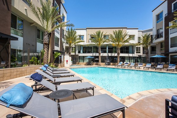 Serene outdoor pool at Accent Apartments with comfortable lounge seating, ideal for relaxation and leisure in a vibrant community setting