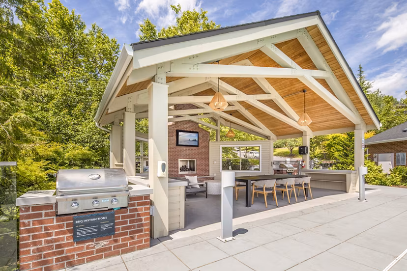 Grill area on patio at Arbor Heights Apartments with seating and greenery Ideal for outdoor gatherings and relaxation