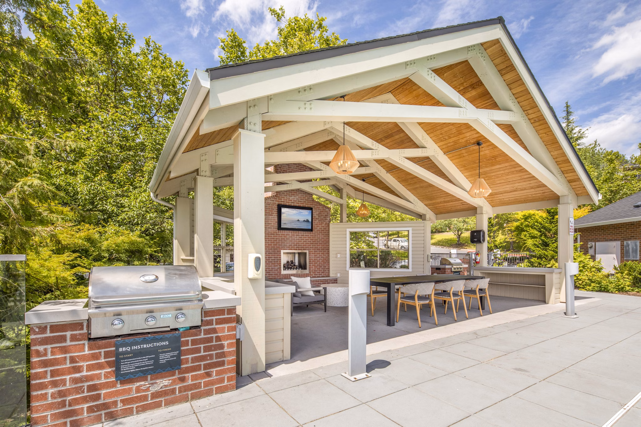 Grill area on patio at Arbor Heights Apartments with seating and greenery Ideal for outdoor gatherings and relaxation
