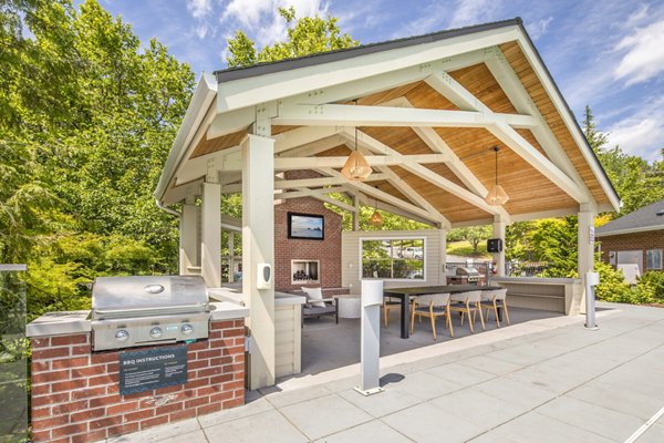 Grill area on patio at Arbor Heights Apartments with seating and greenery Ideal for outdoor gatherings and relaxation