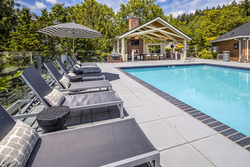 Inviting outdoor pool with surrounding lounge chairs at Arbor Heights Apartments, ideal for relaxation and recreation