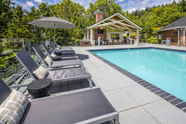 Inviting outdoor pool with surrounding lounge chairs at Arbor Heights Apartments, ideal for relaxation and recreation