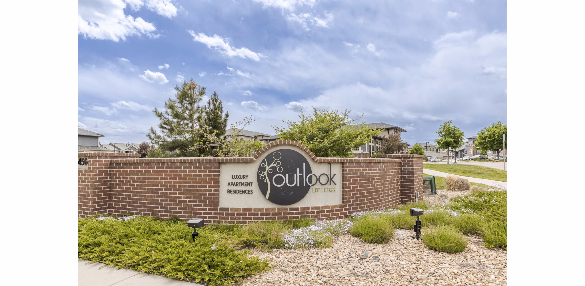 Outlook Littleton: Elegant brick sign for luxury apartments surrounded by landscaped greenery