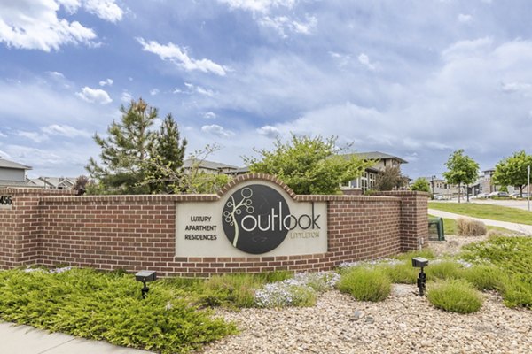 Outlook Littleton: Elegant brick sign for luxury apartments surrounded by landscaped greenery
