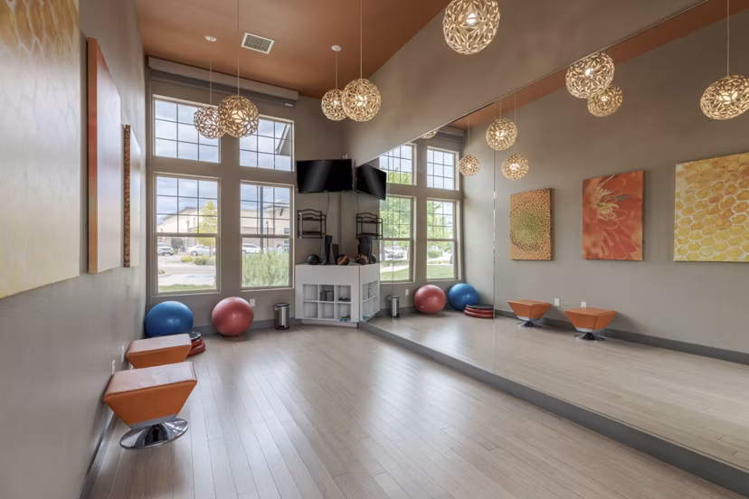 Modern yoga and spin studio with floor-to-ceiling mirrors at Outlook Littleton Apartments, ideal for fitness enthusiasts