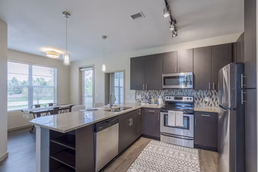Modern kitchen with stainless steel appliances and granite countertops in Outlook Littleton Apartments
