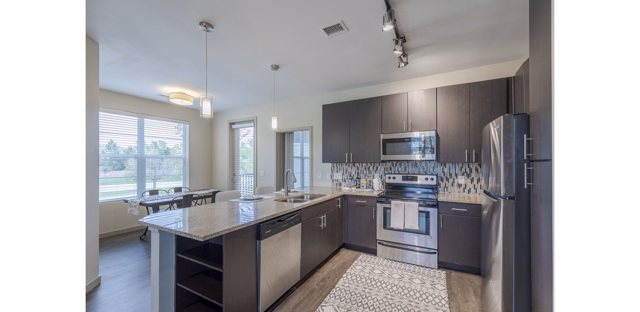 Modern kitchen with stainless steel appliances and granite countertops in Outlook Littleton Apartments