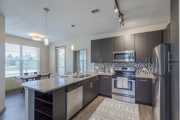 Modern kitchen with stainless steel appliances and granite countertops in Outlook Littleton Apartments