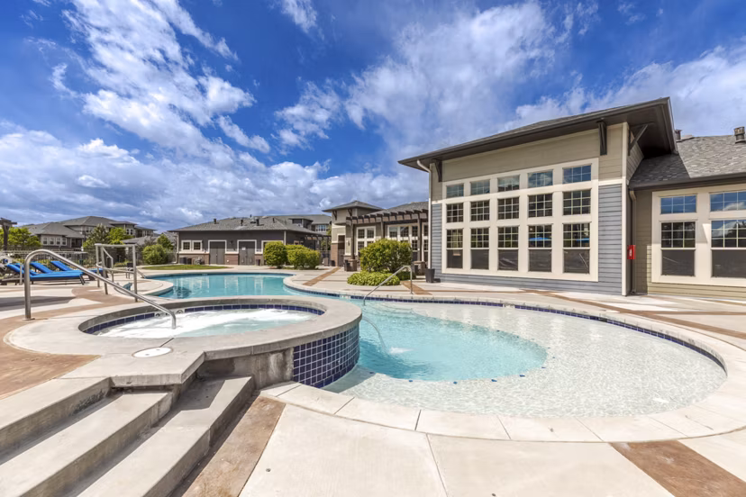 Resort-style pool at Outlook Littleton Apartments, featuring sundeck and loungers, in Colorado luxury community