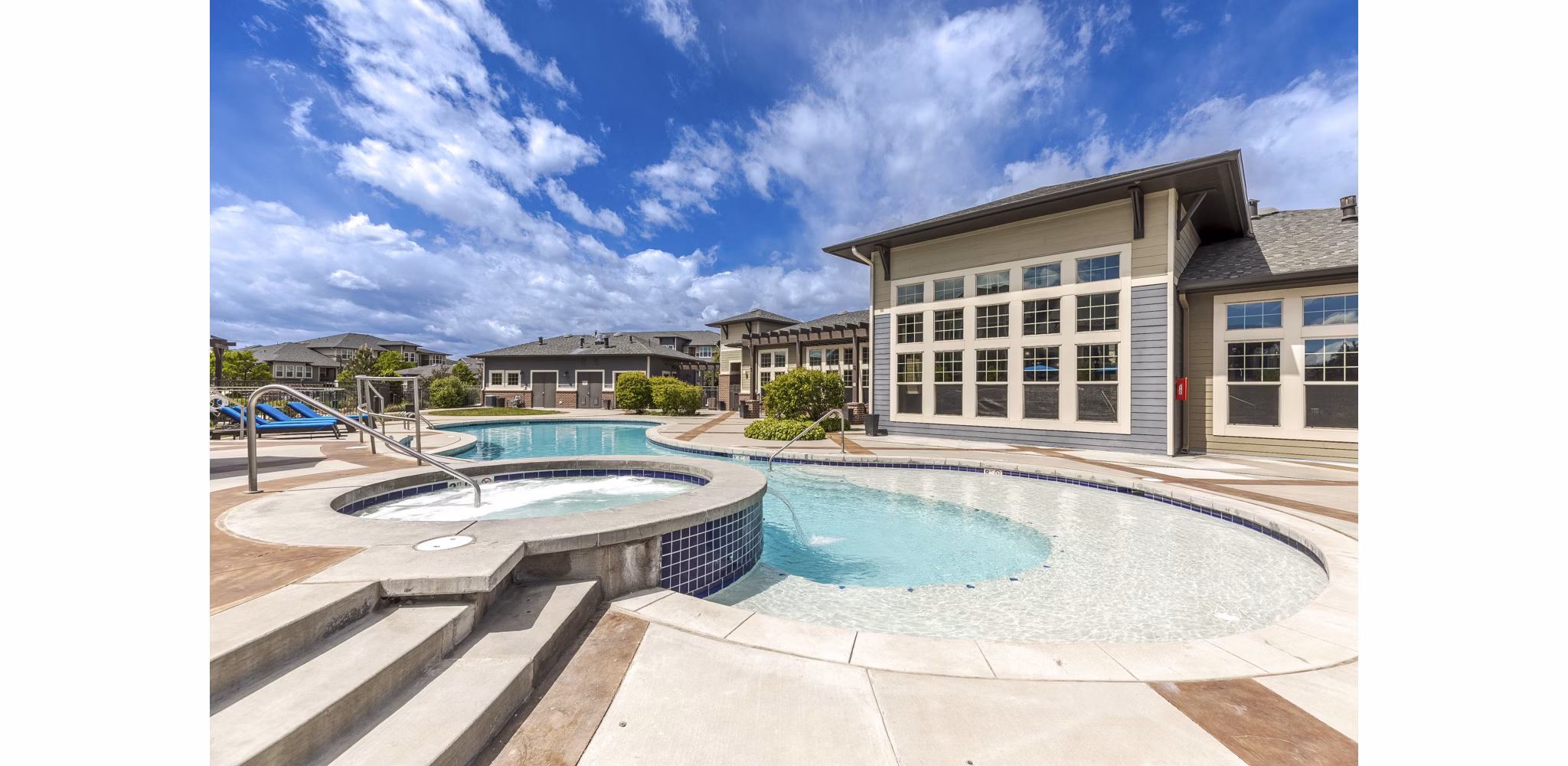 Resort-style pool at Outlook Littleton Apartments, featuring sundeck and loungers, in Colorado luxury community