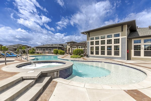 Resort-style pool at Outlook Littleton Apartments, featuring sundeck and loungers, in Colorado luxury community