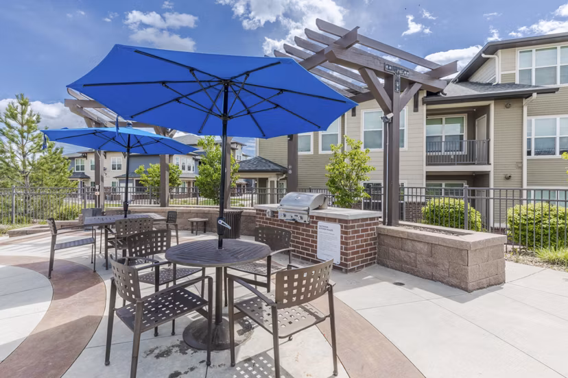 Outdoor grill area with modern seating at Outlook Littleton Apartments, ideal for social gatherings and BBQs in a serene setting