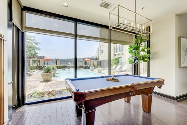 Vibrant game room featuring pool table and lounge seating at Artessa at Quarry Village Apartments