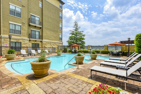Refreshing pool with sun loungers at Artessa at Quarry Village Apartments, offering luxury living and top amenities
