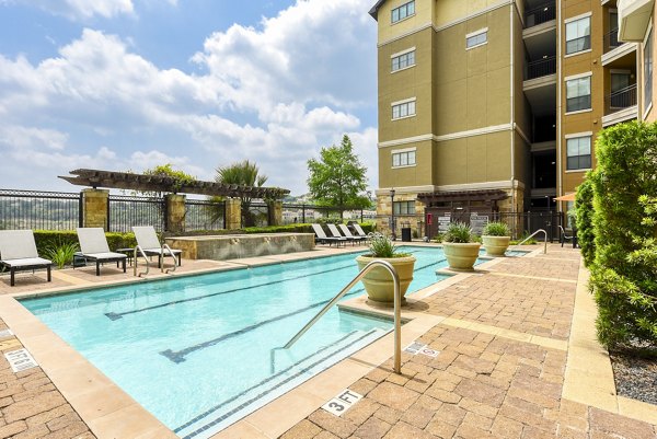 Resort-style pool with lounge chairs at Artessa at Quarry Village Apartments