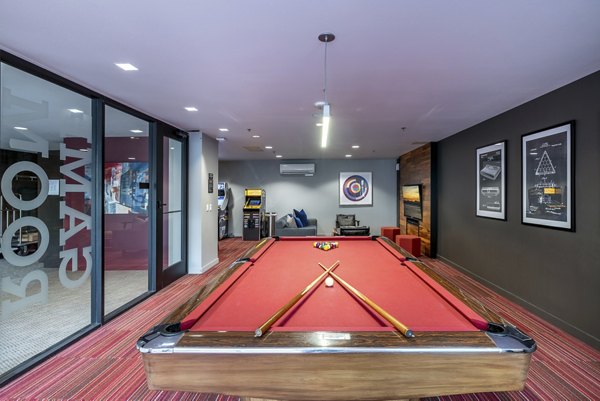 Game room with modern dÃ©cor and pool table at The Luke Apartments