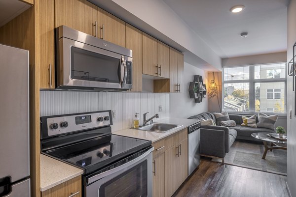 Modern kitchen with stainless steel appliances and granite countertops in The Luke Apartments