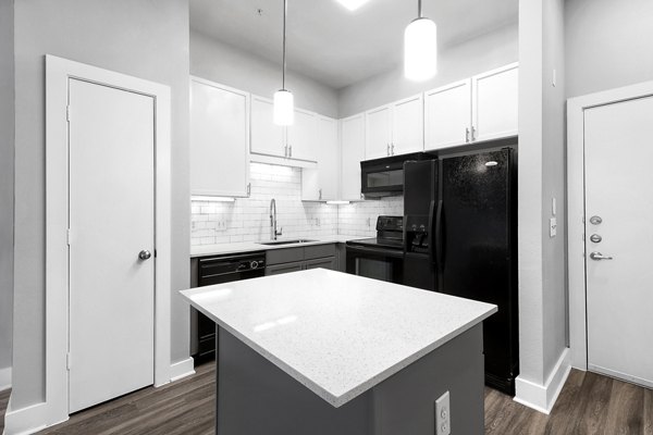 Modern kitchen featuring sleek countertops and stainless steel appliances at Residences at the Triangle Apartments