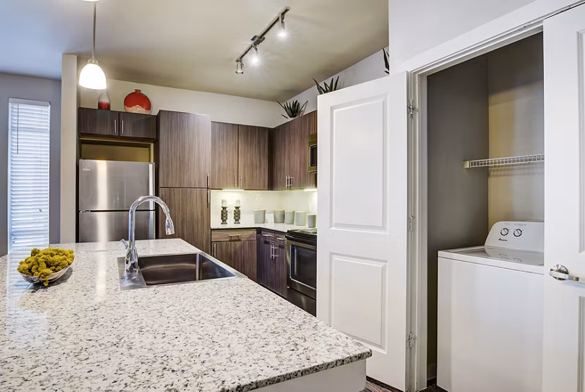 Modern kitchen with stainless steel appliances and granite countertops at Boardwalk Research Luxury Apartments