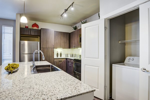Modern kitchen with stainless steel appliances and granite countertops at Boardwalk Research Luxury Apartments