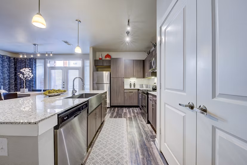 Modern kitchen with granite countertops and stainless steel appliances at Boardwalk Research Luxury Apartments