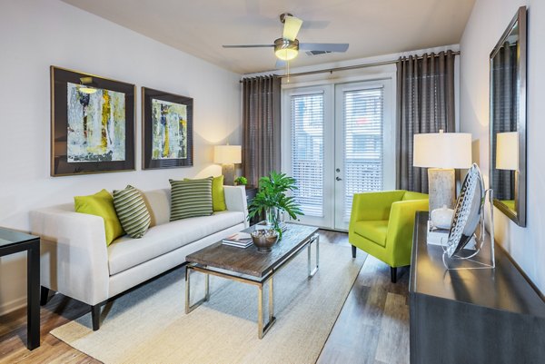 Spacious living room with modern decor in 1100 South Apartments, featuring luxury accents and large windows
