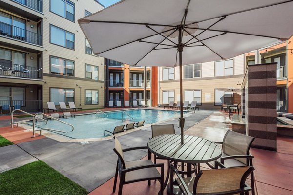 Resort-style pool with lounge seating at 1100 South Apartments, offering luxury living in a vibrant community setting