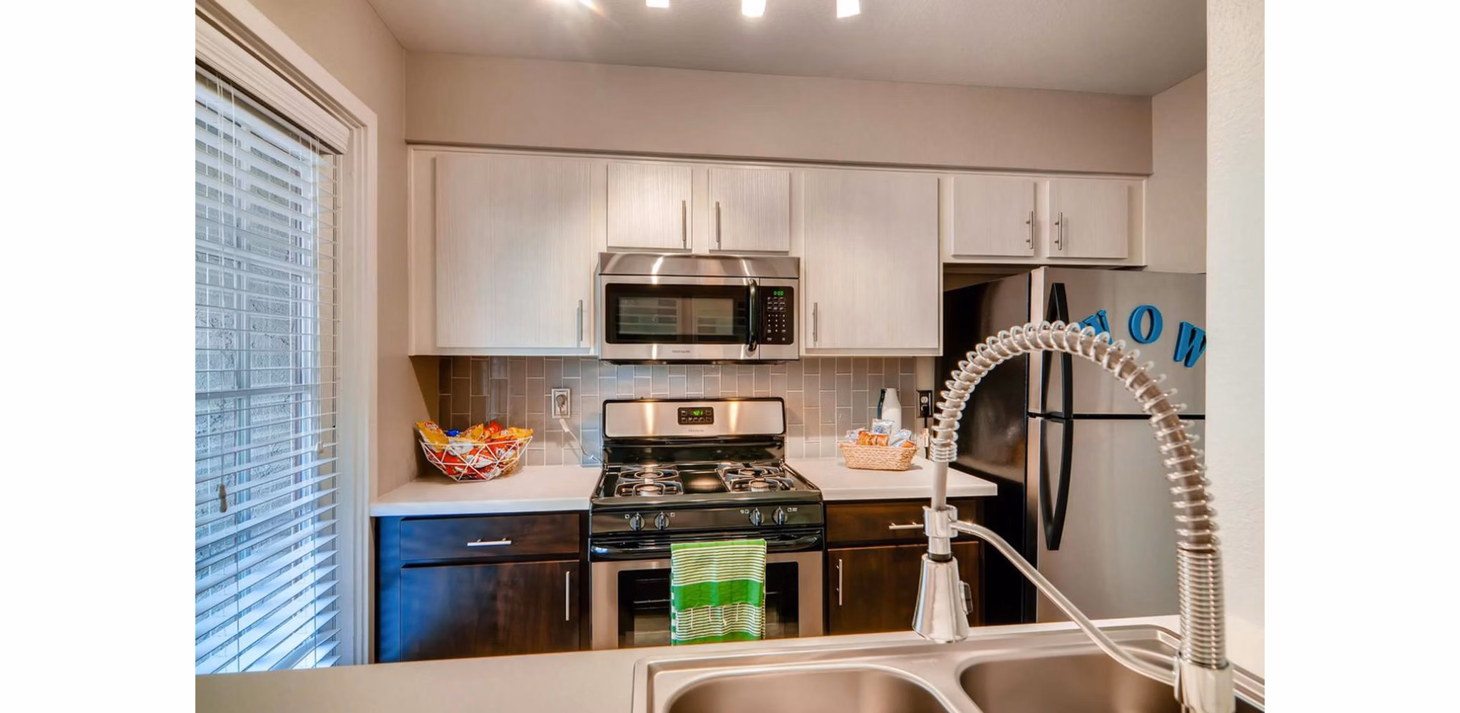 Modern kitchen with stainless steel appliances at The Cortesian Apartments