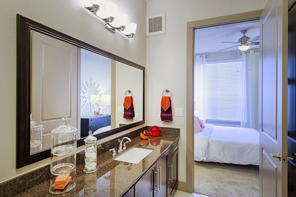 Bathroom with elegant marble countertops and glass shower in Virage Luxury Apartments