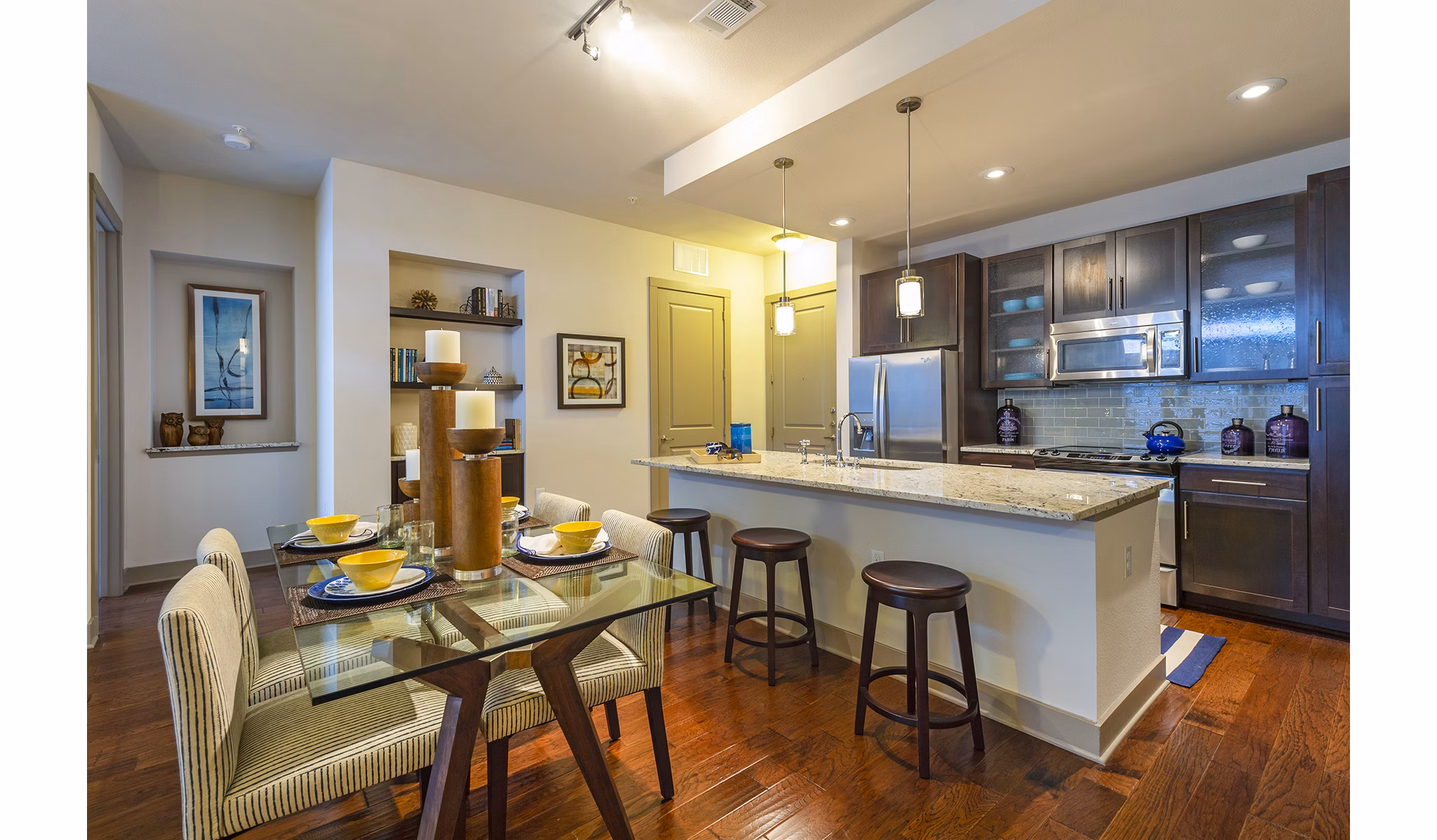 Dining room with modern furniture and pendant lighting at Virage Luxury Apartments