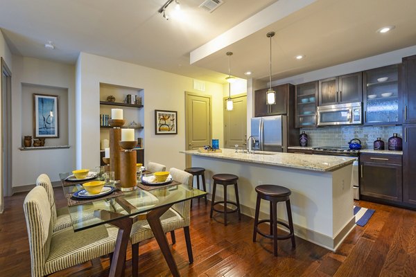 Dining room with modern furniture and pendant lighting at Virage Luxury Apartments