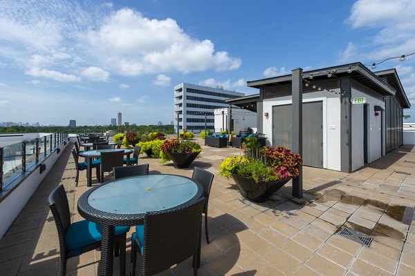 Rooftop deck with seating and skyline views at Virage Luxury Apartments